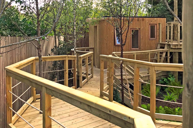 Newly planted trees set in adventure garden walkway